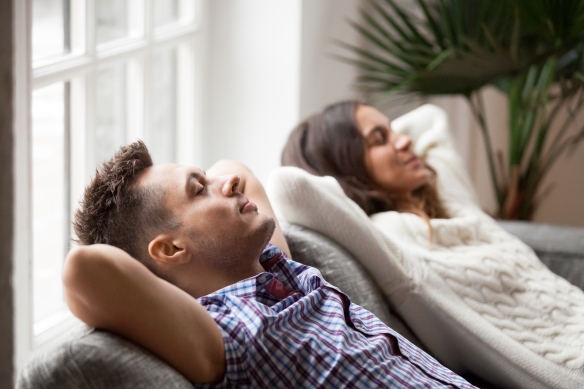 Young Couple Resting On Comfortable Couch Together At Home, Happ